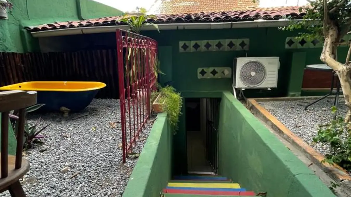 Le patio de Hostel Canto dos Artistas, avec la baignoire jaune et l’escalier multicolore